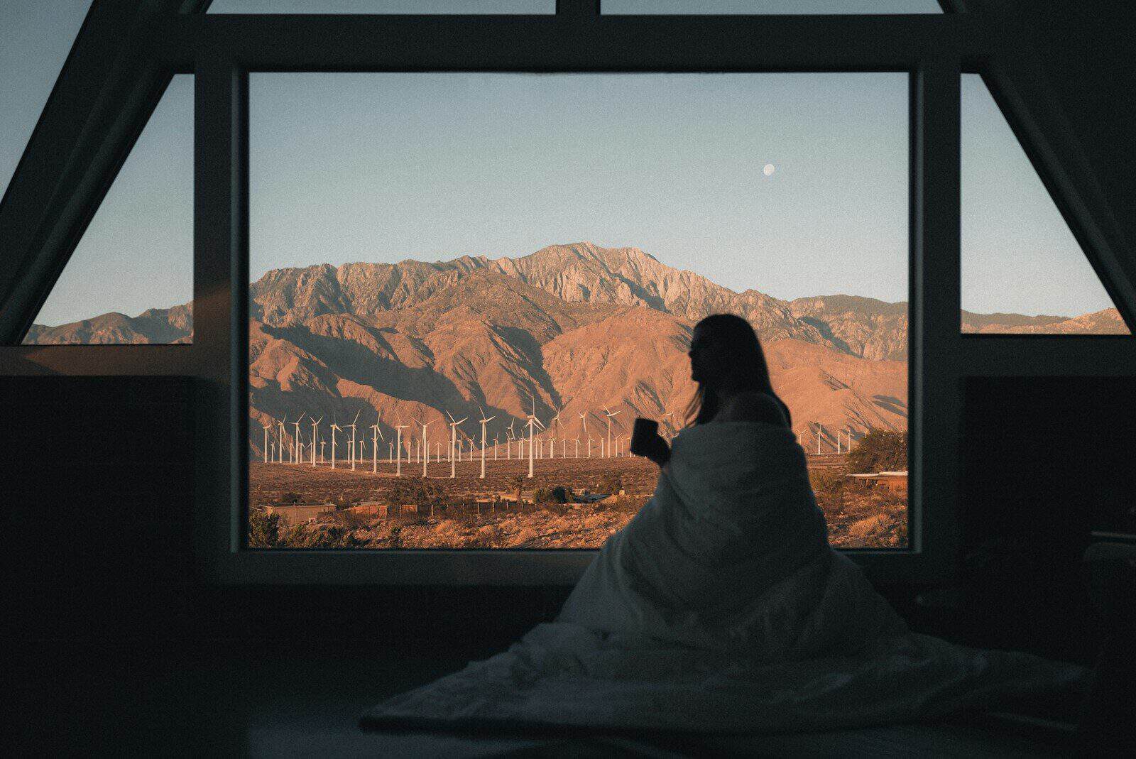 woman looking out the window of her vacation rental